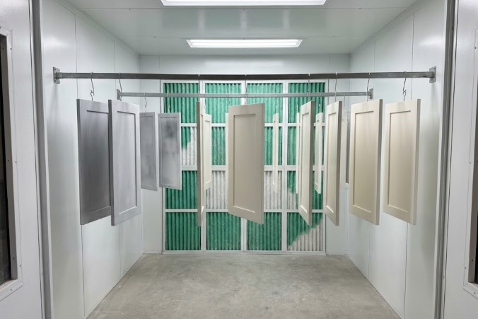 white cabinet doors drying in a spray booth, primed and painted
